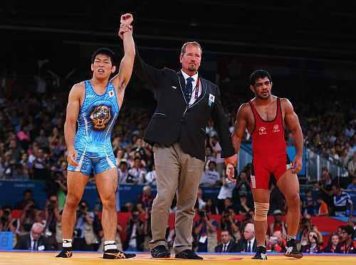 Tatsuhiro Yonemitsu of Japan celebrates his victory against Sushil Kumar of India during the Men's Freestyle 66 kg Wrestling gold medal fight