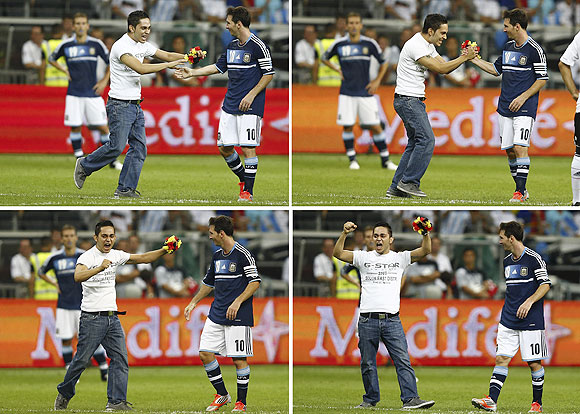 A combination of four pictures shows a pitch invader meeting Argentina's Lionel Messi during the friendly soccer match against Germany in Frankfurt on Wednesday