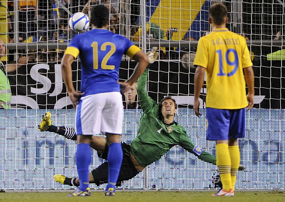 Brazil's Pato (unseen) scores a penalty kick past Sweden's goalkeeper Andreas Isaksson