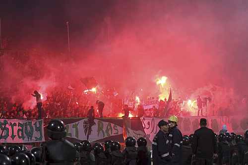 Police officers react as chaos erupts at a soccer stadium in Port Said city