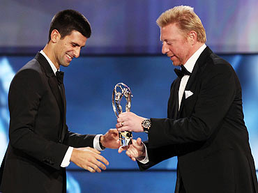 Academy member Boris Becker handS over the Laureus World Sportsman of the Year trophy to Novak Djokovic
