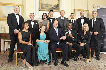 UK Prime Minister David Cameron (centre front) poses for a photograph with sports personalities