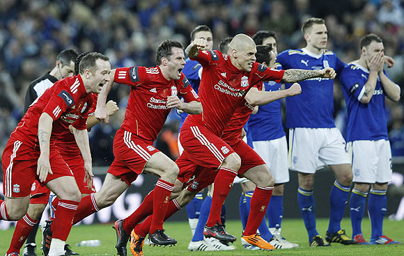 Liverpool's players react after beating Cardiff City on penalties to win the English League Cup final