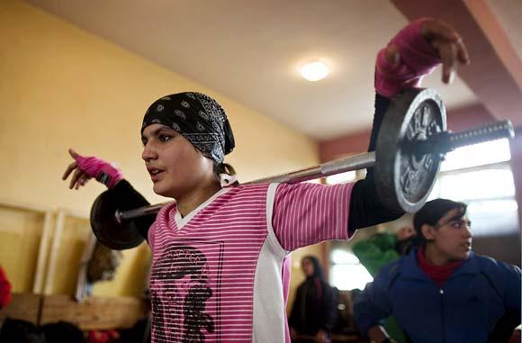 Sadaf Rahimi lifts weights during a practice session in a boxing club in Kabul