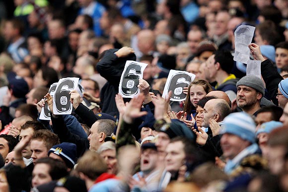 Manchester City fans hold up a reminder of their victory over United earlier in the season