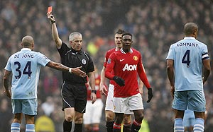 Manchester City's Vincent Kompany (right) is shown a red card by referee Chris Foy during their FA Cup match against Manchester United