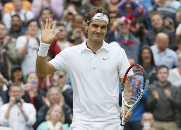 Roger Federer of Switzerland celebrates after defeating Xavier Malisse of Belgium during their men's singles tennis match at the Wimbledon tennis championships in London