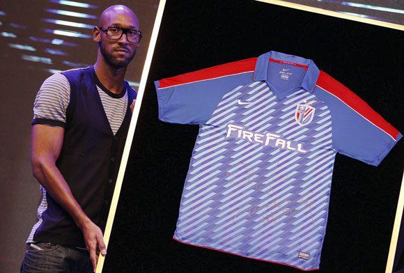 French soccer player Nicolas Anelka of Shanghai Shenhua poses with the Shenhua soccer team jersey during a news conference in Shanghai