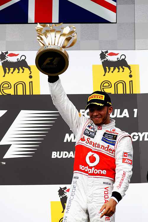 Lewis Hamilton of Great Britain and McLaren celebrates on the podium after winning the Hungarian Formula One Grand Prix