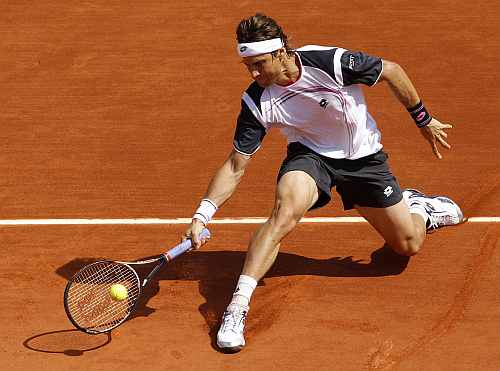 David Ferrer of Spain returns the ball to Mikhail Youzhny of Russia during the French Open tennis tournament at the Roland Garros