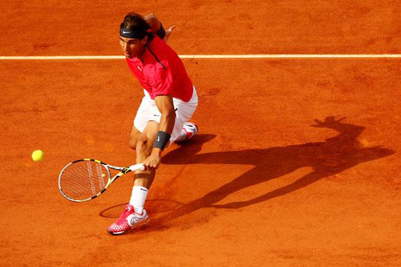 Rafael Nadal of Spain slides across the clay to play a backhand during his men's singles match at the French Open