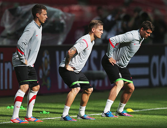 Polish players Adam Matuszczyk (left), Eugen Polanski (centre) and Sebastian Boenisch exercise during a training session on Thursday