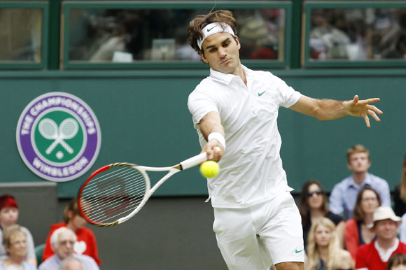 Roger Federer of Switzerland hits a return to Fabio Fognini of Italy during their men's singles tennis match at the Wimbledon tennis championships in London