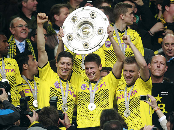 Robert Lewandowski (left), Lukasz Piszczek (centre) and Jakub Blaszczykowski of Borussia Dortmund celebrate with the trophy during a ceremony on Sunday after winning their Bundesliga match against Freiburg in Dortmund