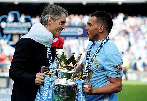 Roberto Mancini the manager of Manchester City and Carlos Tevez of Manchester City celebrate with the EPL trophy