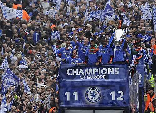 Chelsea football players returning from their Champions League final victory against Bayern Munich are surrounded by fans during a victory parade along the Kings Road in Chelsea