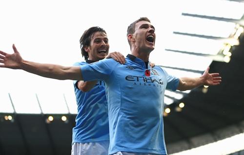 Edin Dzeko of Manchester City celebrates scoring his team's second goal with team-mate David Silva (left)