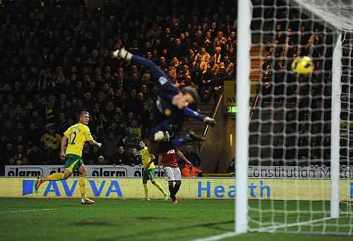 Anthony Pilkington of Norwich City scores his opening goal past goalkeeper Anders Lindegaard of Manchester United during the Barclays Premier League match