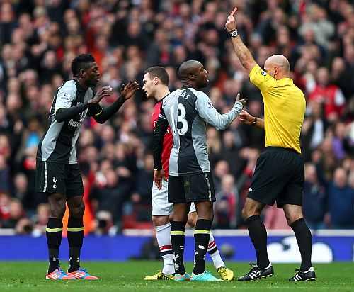 William Gallas protests to referee Howard Webb as team-mate Emmanuel Adebayor of Tottenham Hotspur (L) is shown a red card