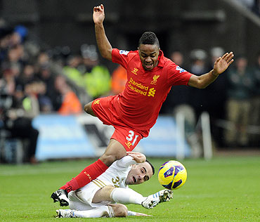 Swansea City's Leon Britton challenges Liverpool's Raheem Sterling (top) during their English Premier League match at the Liberty Stadium in Swansea, on Sunday
