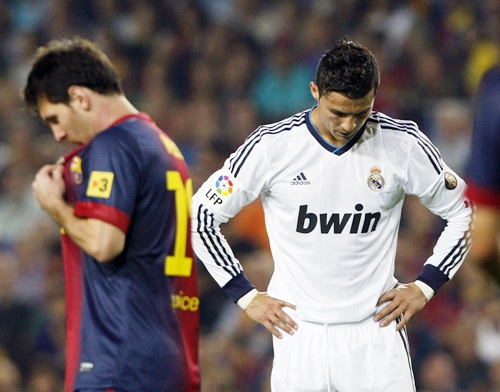 Barcelona's Lionel Messi (left) walks past Real Madrid's Cristiano Ronaldo