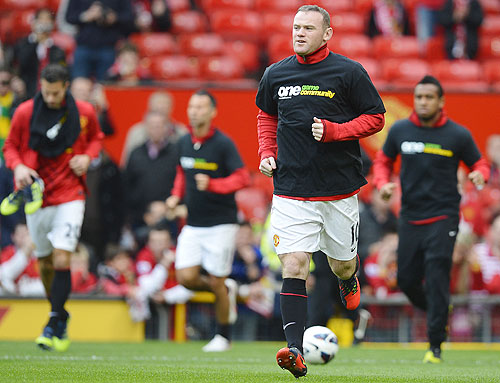 Manchester United's Wayne Rooney (right) wearing an anti racism shirt and Rio Ferdinand (background, left), warm up before their match against Stoke City on Saturday