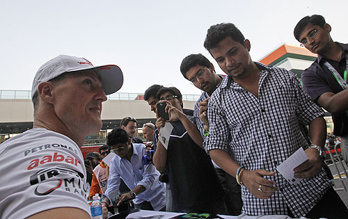 Mercedes Formula One driver Michael Schumacher signs autographs for fans at the Buddh International Circuit in Greater Noida, New Delhi on Thursday