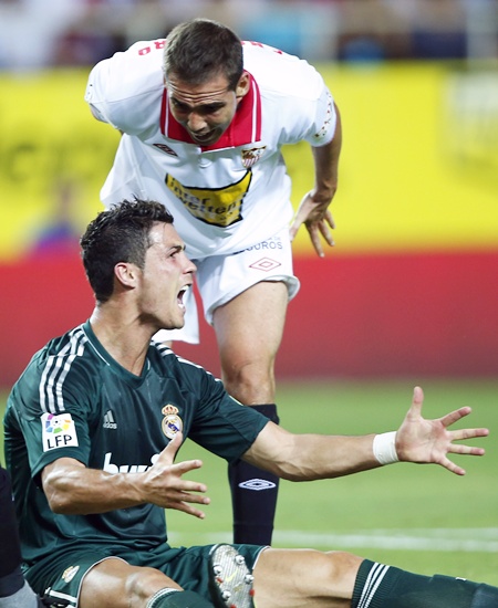 Real Madrid's Cristiano Ronaldo (bottom) reacts next to Sevilla's Fernando Navarro