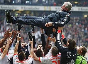 Bayern Munich's players throw coach Jupp Heynckes in the air after winning their German Bundesliga match against Eintracht Frankfurt and the league in Frankfurt on Saturday