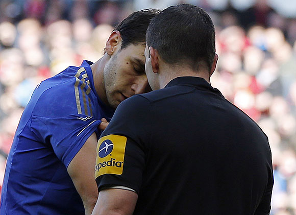 Chelsea's Branislav Ivanovic (left) shows his arm to referee Kevin Friend after Liverpool's Luis Suarez bit him during their English Premier League soccer match at Anfield in Liverpool on Sunday