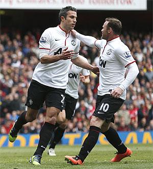 Manchester United's Robin van Persie (left) is congratulated by teammate Wayne Rooney after scoring against Arsenal during their English Premier League match at Emirates Stadium on Sunday