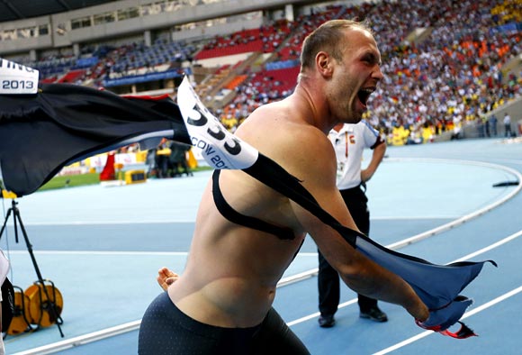Robert Harting of Germany rips off his shirt to celebrate winning gold at the men's discus throw final during the IAAF World Athletics Championships at the Luzhniki stadium in Moscow on Tuesday