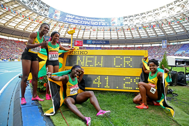 Gold medalists Carrie Russell, Shelly-Ann Fraser-Pryce, Schillonie Calvert and Nickiesha Wilson of Jamaica pose with the clock after setting a new championship record in the Women's 4x100 metres final during Day Nine of the 14th IAAF World Athletics Championships at Luzhniki Stadium