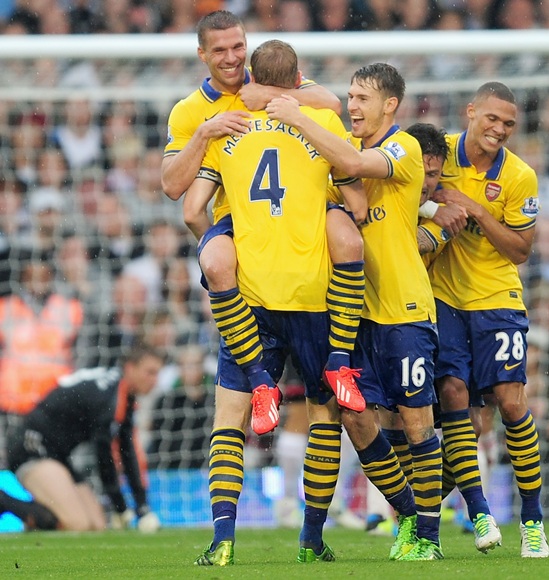 Lukas Podolski of Arsenal (second left) celebrates scoring his side's second goal with Per Mertesacker