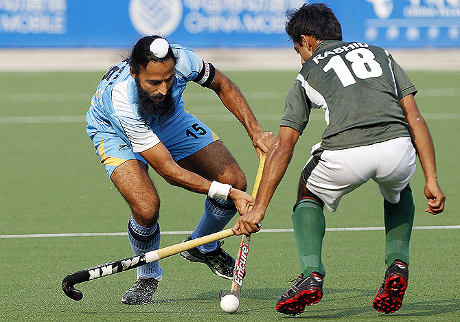 India's Singh Raj Pal (left) battles for the ball with Pakistan's Muhammad Rashid during their match at the 2010 Asian Games in Guangzhou, Guangdong