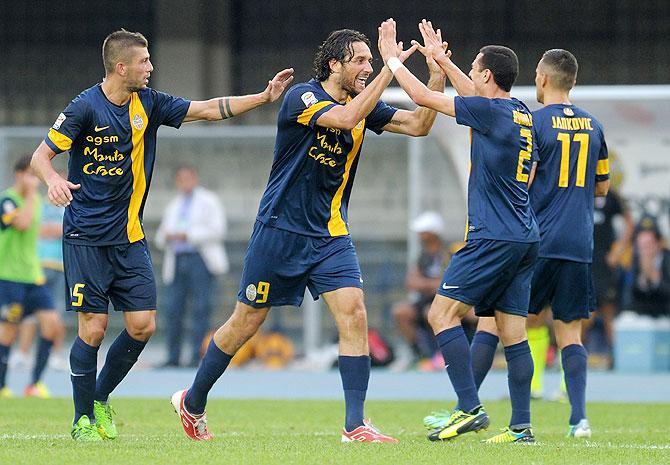 Luca Toni of Hellas Verona FC (2nd from left) celebrates after scoring his second goal against AC Milan during their Serie A match at Stadio Marc'Antonio Bentegodi in Verona, on Saturday