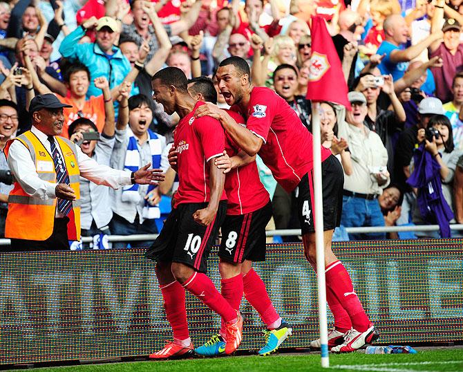 Cardiff City scorers Fraizer Campbell (left) and teammates lead the celebrations after the third Cardiff goal against Manchester City at Cardiff City Stadium in Cardiff, Wales, on Sunday