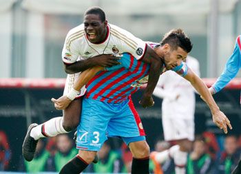 Nicolas Spolli (right) of Catania challenges Mario Balotelli of Milan during their Serie A match at Stadio Angelo Massimino in Catania on Sunday