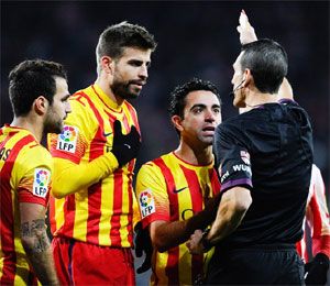  Cesc Fabregas, Gerard Pique, Xavi Hernandez and Andres Iniesta of FC Barcelona argue with the Referee Juan Martinez Munuera