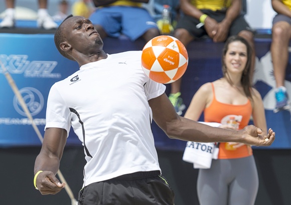 Jamaican Olympic champion Usain Bolt plays footvolley, a combination of soccer and volleyball, one day before the Mano a Mano challenge on Copacabana beach in Rio de Janeiro