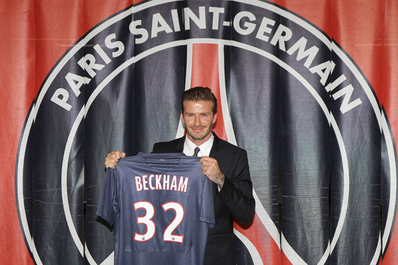 David Beckham poses with his PSG Football shirt after his PSG signature at Parc des Princes