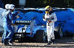 Mercedes GP's Lewis Hamilton walks away from his car after crashing into the gravel at turn six during Formula One winter testing at Circuito de Jerez on Wednesday