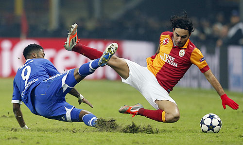 Galatasaray's Selcuk Inan (right) and Schalke 04's Michel Bastos (left) fall during a challenge in their Champions League match on Wednesday