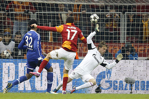 Galatasaray's Burak Yilmaz (centre) scores past Schalke 04's goalkeeper Timo Hildebrand (right) and Joel Matip (left) during their Champions League match on Wednesday
