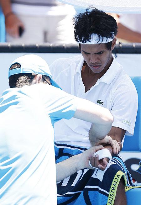 Somdev Devvarman receives medical attention during the men's singles match against Jerzy Janowicz on Wednesday