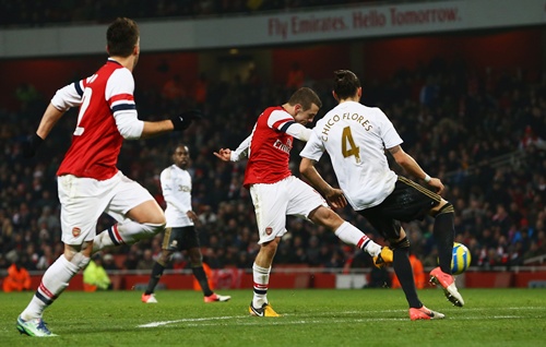 Jack Wilshere of Arsenal (centre) shoots past Chico Flores of Swansea City