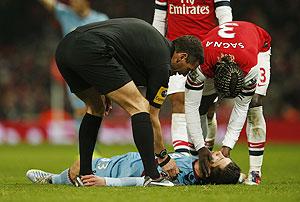 West Ham's Daniel Potts is checked by Arsenal's Bacary Sagna (R) and referee Andre Marriner after he was injured during their match on Wednesday