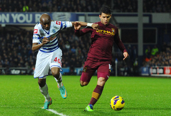 Sergio Arguero of Manchester City is pursued by Stephane Mbia of QPR during the Premier League match at Loftus Road
