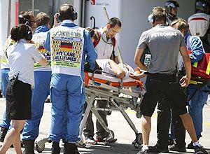 A cameraman is carried on a stretcher after being injured by a lost rear tyre of Red Bull Formula One driver Mark Webber of Australia during the German F1 Grand Prix at the Nuerburgring circuit on Sunday