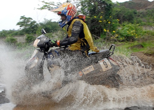 Muzaffar Ali negotiates a water-logged area during the Gulf Monsoon scooter rally